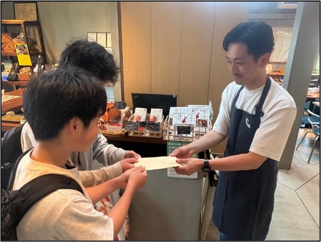 募金を手渡しする生徒
