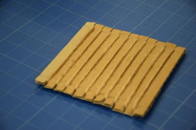 段ボールコースターに紐を巻けたもの