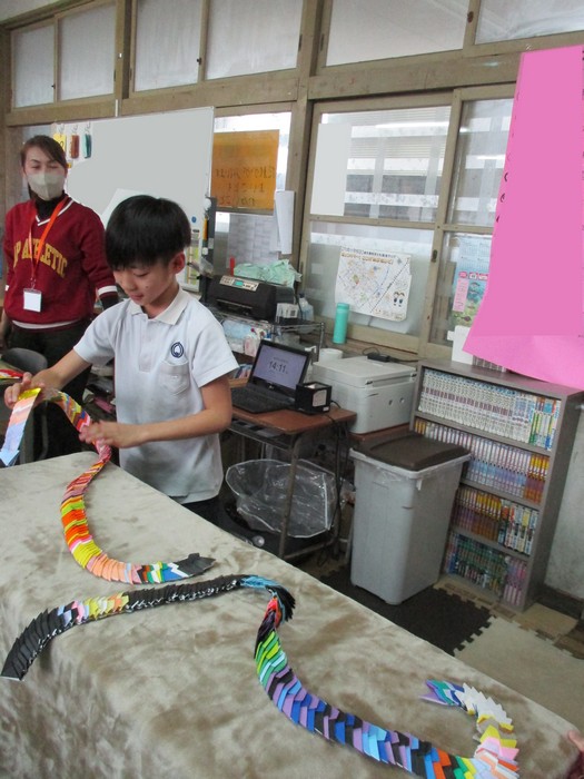 折り紙を見せる子ども