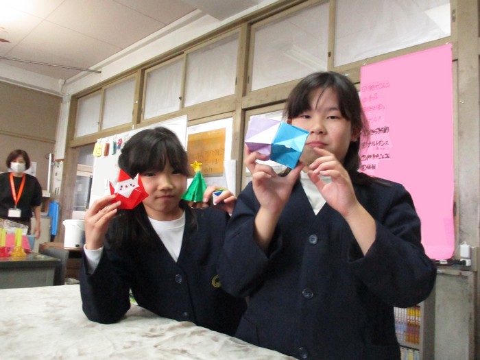 折り紙mを見せる子どもたち