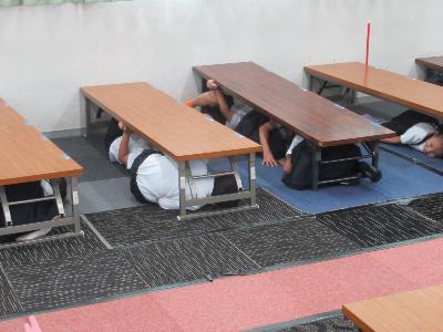 机の下に入る子どもたち