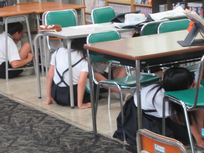 机の下に入る子どもたち